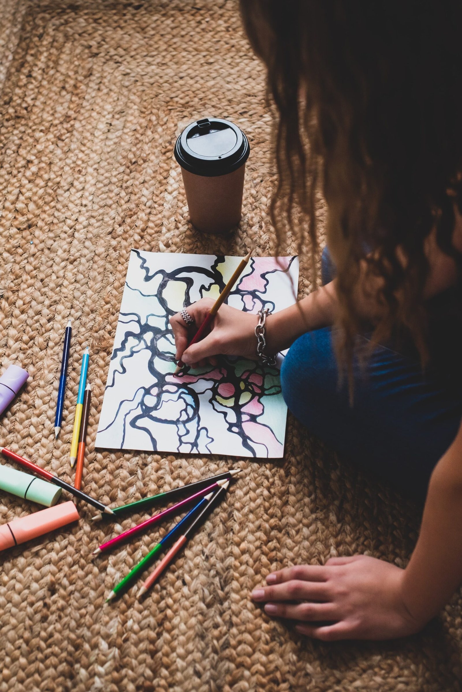 Person focused on drawing neurographic art, creating intricate lines and colorful shapes.