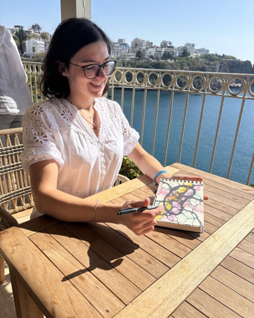 Ana Jomir drawing outdoors by the water